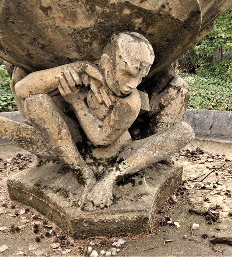 Skulpturen aus dem Kolbe Museum in Westend. Zwei oder drei Personen sitzen auf dem Boden und tragen einen großen Stein auf ihren Rücken.